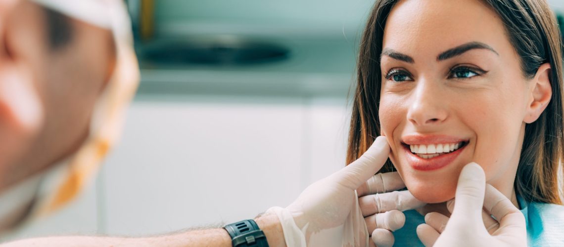 Young smiling woman with beautifiul teeth, having a dental inspection